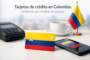 Imagen de una tarjeta bancaria con los colores de Colombia colocada sobre una superficie junto a un datáfono, un teléfono móvil mostrando una tarjeta digital y una taza de café. Al fondo, una pequeña bandera colombiana refuerza el contexto local. La escena representa el uso moderno de tarjetas de crédito en Colombia, destacando la digitalización de pagos, la integración con dispositivos móviles y las nuevas formas de consumo financiero en el país.