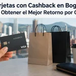 Imagen realista y minimalista sobre tarjetas de crédito con cashback en Bogotá. Una mano sostiene una tarjeta bancaria oscura con la palabra “Cashback”, mientras al fondo aparecen bolsas de compras elegantes, una billetera negra y un vaso de café sobre una mesa moderna. En el fondo se observa el paisaje urbano de Bogotá desenfocado con montañas y edificios de la ciudad. En la parte superior de la imagen aparece el título destacado: “Tarjetas con Cashback en Bogotá: ¿Dónde Obtener el Mejor Retorno por Compra?”.